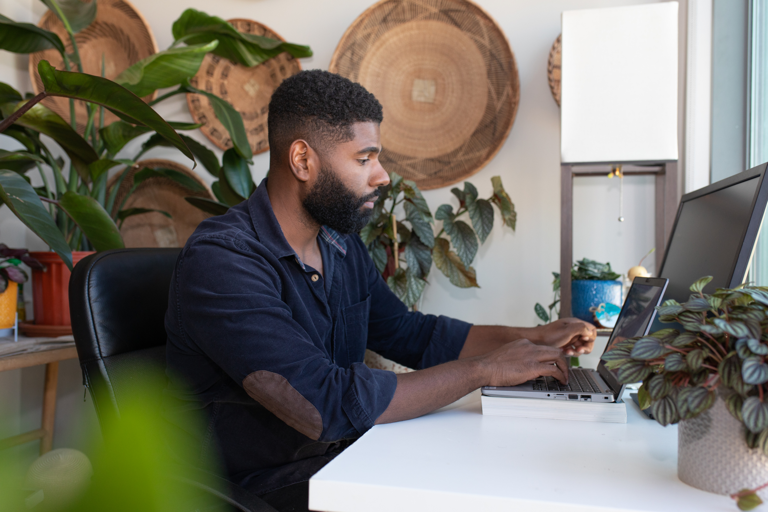 man typing on a laptop